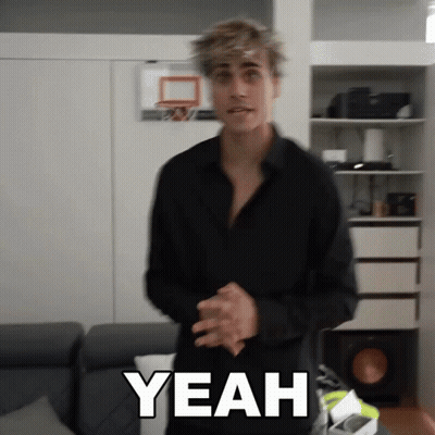 A Man In A Black Shirt Is Standing In Front Of A Basketball Hoop And Says Yeah GIF