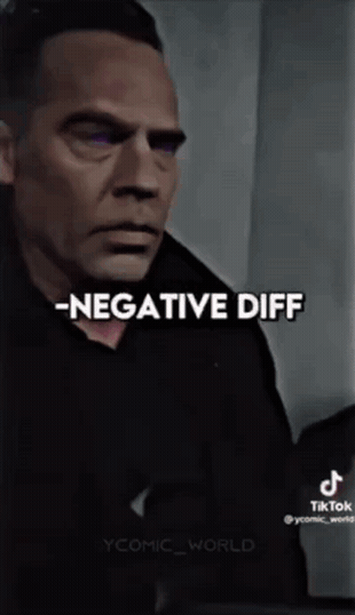 A Man In A Black Shirt Is Standing In Front Of A Wall With The Words `` Negative Diff '' Written On It . GIF