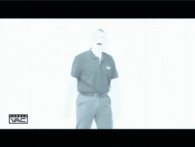 A Man In A Black Shirt Is Standing In Front Of A White Wall With The Word Vac Written On It GIF