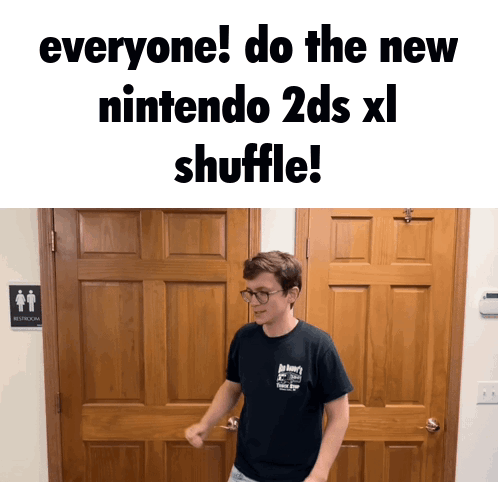 A Man In A Black Shirt Is Standing In Front Of A Wooden Door And A Sign That Says Restroom GIF