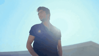A Man In A Black Shirt Is Standing In The Sunlight GIF