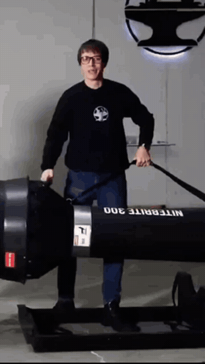 A Man In A Black Shirt Is Standing Next To A Nitebrite 300 GIF