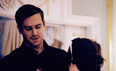 A Man In A Black Shirt Is Standing Next To A Woman In A Dark Room . GIF