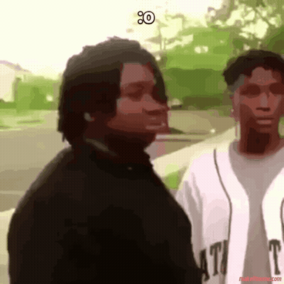 A Man In A Black Shirt Is Standing Next To A Woman In A White Shirt That Says T. GIF