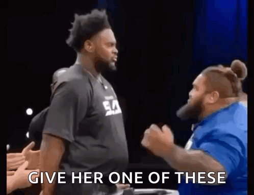 A Man In A Black Shirt Is Standing Next To Another Man In A Blue Shirt And Yelling At Him . GIF