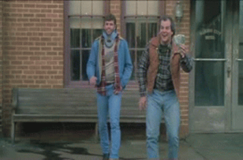A Man In A Black Shirt Is Standing Next To Another Man GIF