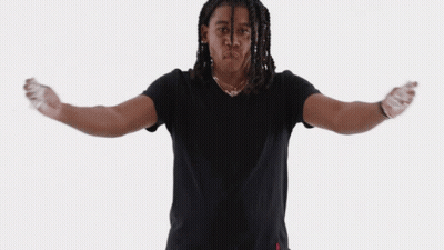 A Man In A Black Shirt Is Standing With His Arms Outstretched In Front Of A White Background GIF