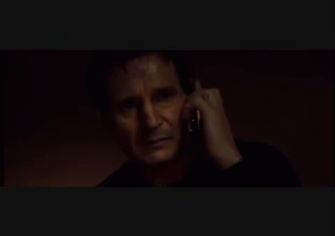 A Man In A Black Shirt Is Talking On A Cell Phone GIF