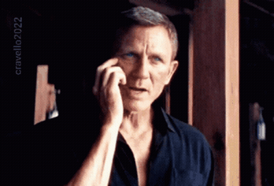 A Man In A Black Shirt Is Talking On A Cell Phone With The Year 2022 In The Corner GIF