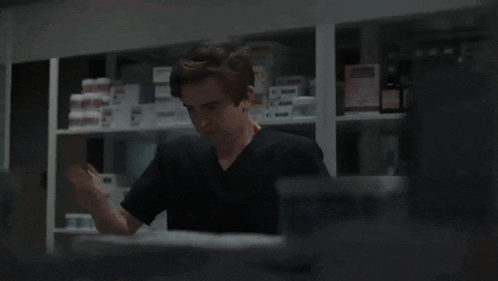 A Man In A Black Shirt Is Talking To A Doctor In A White Coat GIF