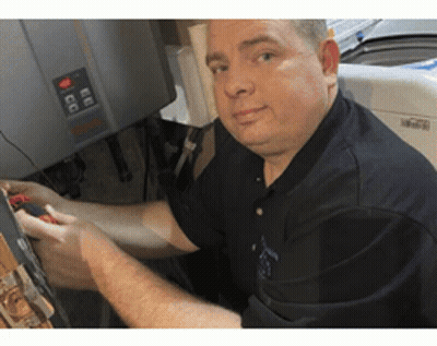 A Man In A Black Shirt Is Working On A Washer And Dryer . GIF