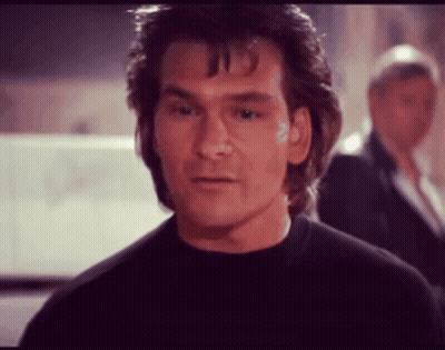 A Man In A Black Shirt Looks At The Camera GIF