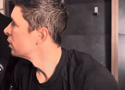 A Man In A Black Shirt Looks To His Left GIF