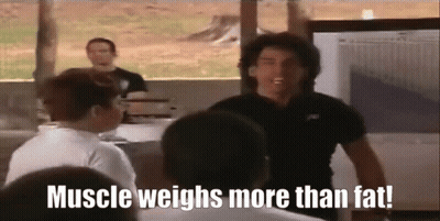 A Man In A Black Shirt Says Muscle Weighs More Than Fat In Front Of A Group Of People GIF