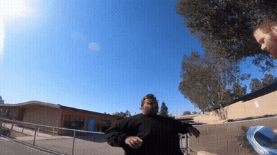 A Man In A Black Shirt Stands In Front Of A Building GIF