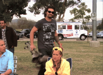 A Man In A Black Shirt Stands In Front Of A Food Truck That Says Ice Cream GIF