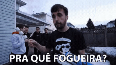 A Man In A Black Shirt Stands In Front Of A Group Of People With The Words Pra Que Fogeira Written Below Him GIF