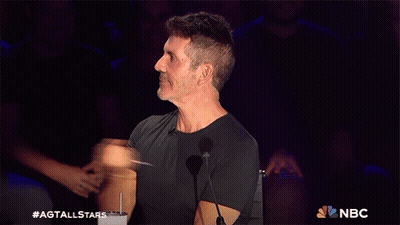 A Man In A Black Shirt Stands In Front Of A Microphone With The Nbc Logo In The Corner GIF