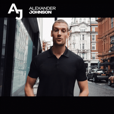 A Man In A Black Shirt Stands In Front Of A Sign That Says " Alexander Johnson " GIF