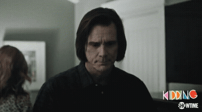 A Man In A Black Shirt Stands In Front Of A Sign That Says Kidding GIF