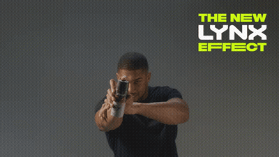 A Man In A Black Shirt Stands In Front Of A Sign That Says " The New Lynx Effect " GIF