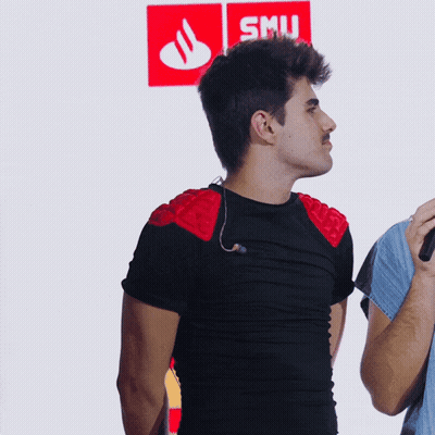 A Man In A Black Shirt Stands In Front Of A Smu Sign GIF