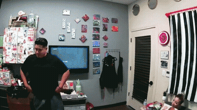 a man in a black shirt stands in front of a television that says ' nintendo ' on the screen