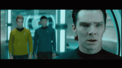 A Man In A Black Shirt Stands In Front Of Two Other Men GIF