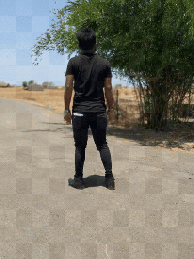 A Man In A Black Shirt Stands On The Side Of The Road GIF