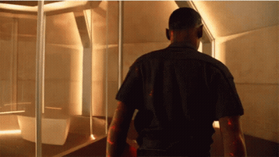 A Man In A Black Shirt Walks Through A Room GIF