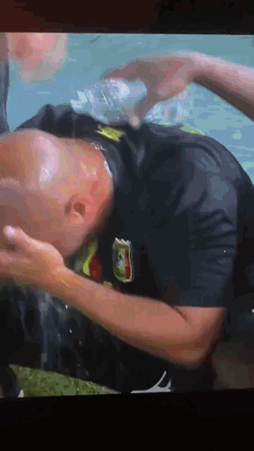 A Man In A Black Shirt With A Mexico Flag On It Is Laying In The Water GIF