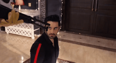 A Man In A Black Shirt With Red Stripes Is Holding A Gun To His Head . GIF