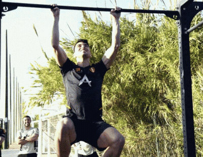 A Man In A Black Shirt With The Letter A On It Is Doing Pull Ups GIF