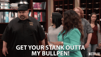 A Man In A Black Shirt With The Letter W On It Stands In Front Of A Group Of People GIF