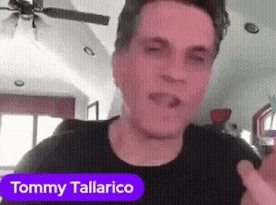 A Man In A Black Shirt With The Name Tommy Tallarico On A Purple Sticker GIF