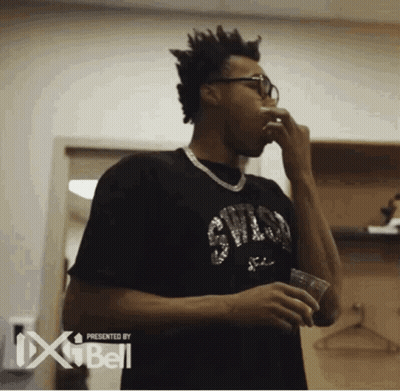 A Man In A Black Shirt With The Word Chicago On It Holds A Cup GIF