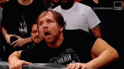 A Man In A Black Shirt With The Word Dean On It Is Sitting In A Ring With His Mouth Open . GIF