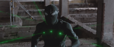 A Man In A Black Spiderman Costume Is Surrounded By Green Lasers GIF