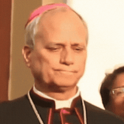 A Man In A Black Suit And A Pink Hat Looks Down GIF