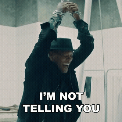 A Man In A Black Suit And Hat Says I 'M Not Telling You While Holding Up His Hands GIF