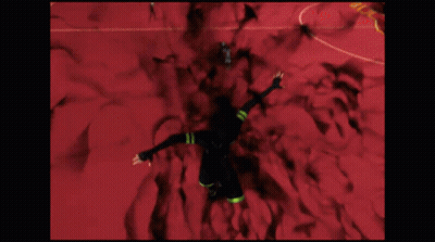A Man In A Black Suit Is Flying Through A Red Room With A Sign That Says G-Z GIF