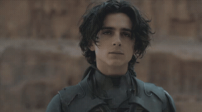 A Man In A Black Suit Is Holding A Knife GIF