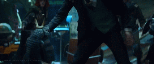 A Man In A Black Suit Is Kneeling Down In Front Of A Group Of Soldiers . GIF