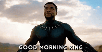 A Man In A Black Suit Is Standing In Front Of A Cloudy Sky And Says Good Morning King . GIF