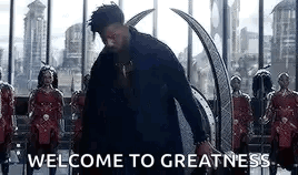 A Man In A Black Suit Is Standing In Front Of A Group Of Soldiers And Says Welcome To Greatness . GIF