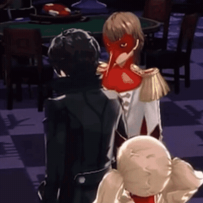 A Man In A Black Suit Is Standing Next To A Woman In A Red Mask .. GIF