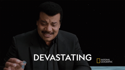 A Man In A Black Suit Stands In Front Of A Black Background With Devastating Written On It GIF