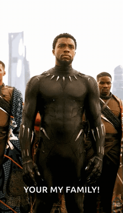 A Man In A Black Suit Stands In Front Of A Group Of Men With The Words Your My Family Below Him GIF