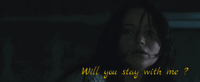 A Man In A Black Suit Stands In Front Of A Window GIF