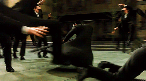 A Man In A Black Suit With The Letter L On The Back Of His Shirt GIF